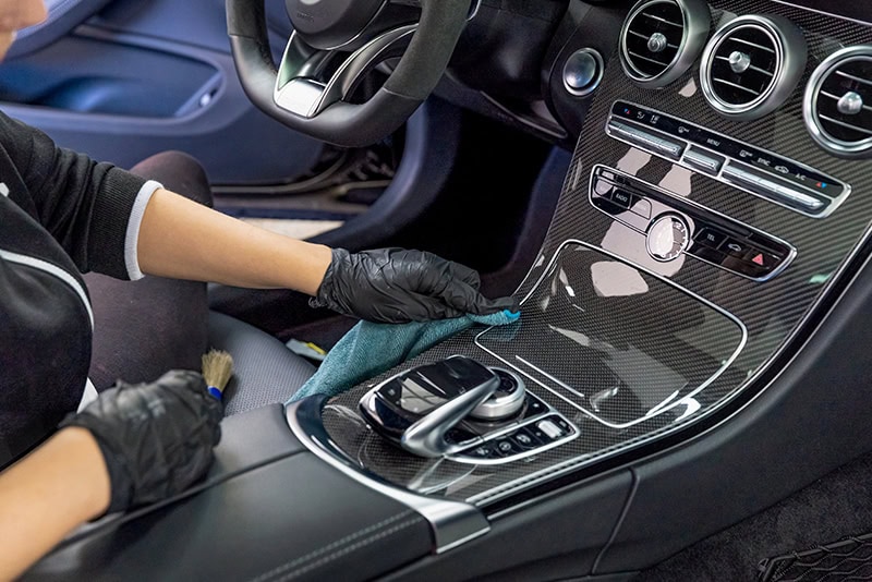 High-quality car detailing inside a luxury vehicle with professional cleaning tools.